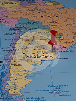 Close-up of a world map with a pin pointing to the location of Argentina, Buenos Aires