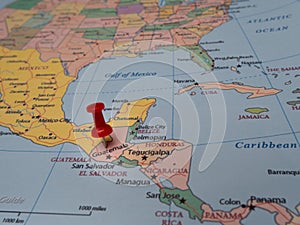 Close-up of a world map with a pin pointing to the location of Guatemala