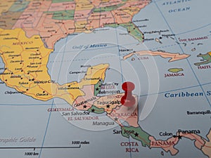 Close-up of a world map with a pin pointing to the location of Nicaragua