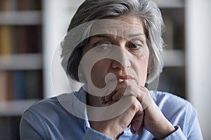 Close up worried middle-aged woman deep in sad thoughts