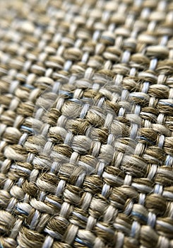 Close-up of a woven fabric featuring a textured pattern of beige and gray threads