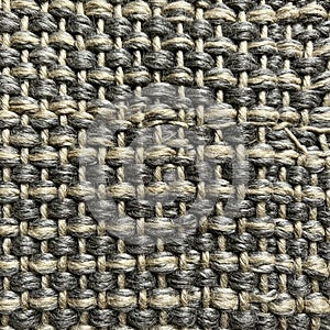 Close-up of a woven fabric with a textured pattern featuring interlocking loops of yarn
