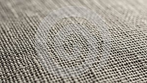Close up of a woven textile fabric featuring a coarse beige colored texture