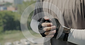 Close-up of wrapped hands of male boxer hitting fists preparing for fight in modern gym