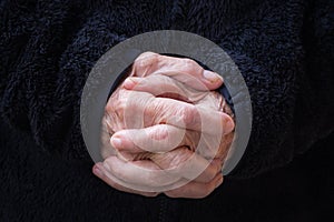 Close-up of wrinkled hands senior woman joined together for prayer. Concept of aged people and religion