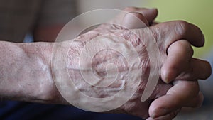 Close-up of the wrinkled sinewy hands of an elderly man meditating. The pensioner crossed his palms. Selective focus. macro