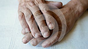 Close-up of the wrinkled tired hands of an elderly man with unkempt nails. Pensioner`s hands. Hand on a man`s hand, selective focu