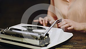 Close up of writer`s hands prints on vintage typewriter. Typing on old typewriter. Woman`s hand typing on retro machine