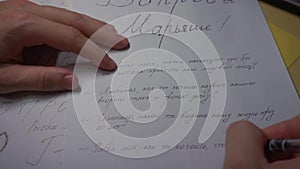 Close-up of writing hand with pen on paper letter in Russian