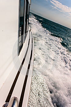 Close up of yacht mast and silver sail on blue sky background. Sailing boat part. Yachting, sailing, competitio