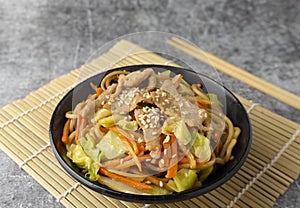 Close up Yakisoba noodle with pork, Japanese food in a black bowl