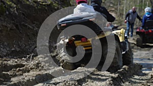 Close-up of a yellow ATV riding on dirt in the woods. Selective focus. Extreme type of outdoor activities. Touring rides