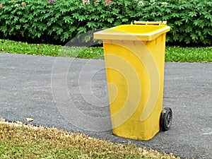 Close up of yellow bins in public park beside the walk way