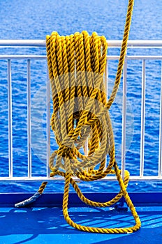 Yellow braided rope draped over a ship railing