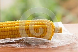 Close up yellow corn on wooden table and nature background.