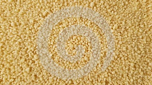 Close up of yellow golden dry couscous top view from above. Macro food us a background with copy space from above. Nutrition vegan