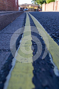 a close up of yellow lines on an english road using selective focus