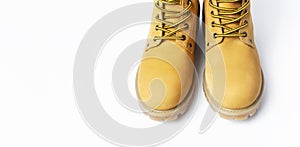 Close-up Yellow men`s work boots from natural nubuck leather isolated on white background. Trendy casual shoes, youth style.