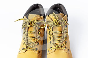 Close-up Yellow men`s work boots from natural nubuck leather isolated on white background. Trendy casual shoes, youth style.