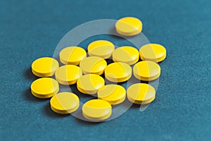 close up of yellow pills on a blue background