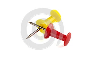 Close-up of yellow and red push pins isolated on white background.