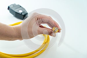 Close up of yellow RJ-45 cable on hand. 