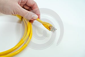 Close up of yellow RJ-45 cable on hand. Isolated