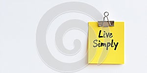 Close-Up of a Yellow Sticky Note with Live Simply in Handwriting, Isolated on White Background