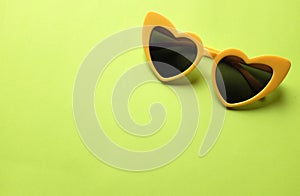 Close up  yellow sunglasses isolate on a green background