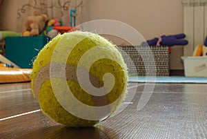 Close-up of a yellow tennis ball on the floor in the nursery