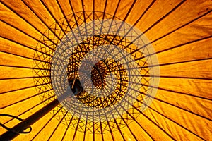 Close up of a yellow traditional burmese parasol, view from inside, asian background