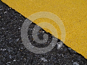 Close up of Yellow traffic lines on the dark asphalt road background