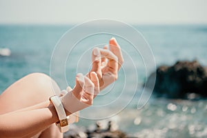 Close up Yoga Hand Gesture of Woman Doing an Outdoor meditation. Blurred sea background. Woman on yoga mat in beach
