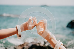 Close up Yoga Hand Gesture of Woman Doing an Outdoor meditation. Blurred sea background. Woman on yoga mat in beach