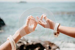 Close up yoga hand gesture of woman doing an outdoor meditation. Blurred sea background. Woman on yoga mat in beach