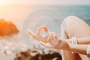 Close up Yoga Hand Gesture of Woman Doing an Outdoor meditation. Blurred sea background. Woman on yoga mat in beach