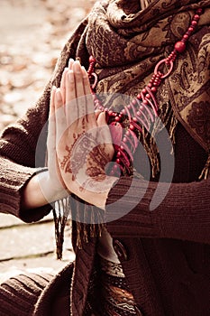 Close up of yoga woman hands in namaste gesture  with henna drowing on hands outdoor shot