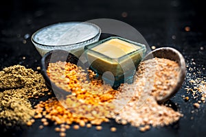 Close up of yogurt or curd face pack with honey,lemon juice,turmeric powder for acne skin on wooden surface in a glass container