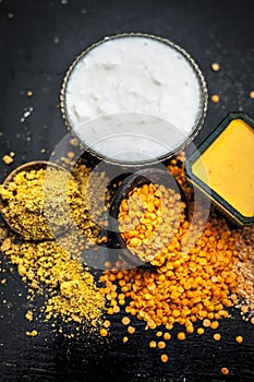 Close up of yogurt or curd face pack with honey,lemon juice,turmeric powder for acne skin on wooden surface in a glass container