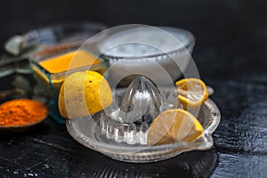 Close up of yogurt or curd face pack with honey,lemon juice,turmeric powder for acne skin on wooden surface in a glass container w