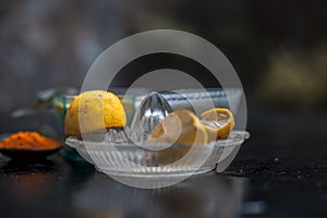 Close up of yogurt or curd face pack with honey,lemon juice,turmeric powder for acne skin on wooden surface in a glass container w