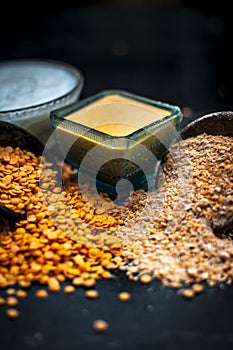 Close up of yogurt or curd face pack with honey,lemon juice,turmeric powder for acne skin on wooden surface in a glass container w