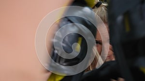 Close-up of a young active woman engaged in boxing with a trainer.