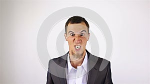 Close up of young adult man full of fury, looking at the camera. Swears