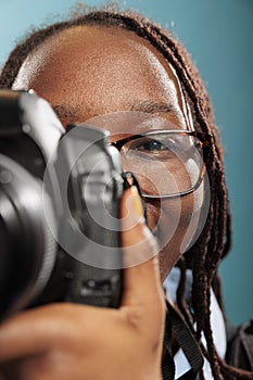 Close up of young adult woman with photography hobby and DSLR device taking photos.