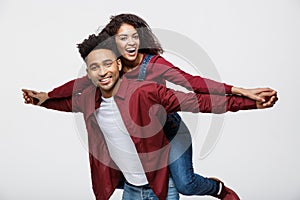 Close-up young african american couple riding back and playing like plane.