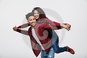 Close-up young african american couple riding back and playing like plane.