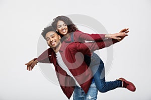 Close-up young african american couple riding back and playing like plane.