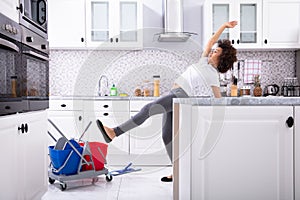 Una mujer resbalones mientras trapear piso en La cocina 