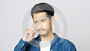 Close up of young asian man serious thinking while standing over isolated grey background with copy space for text, Portrait of